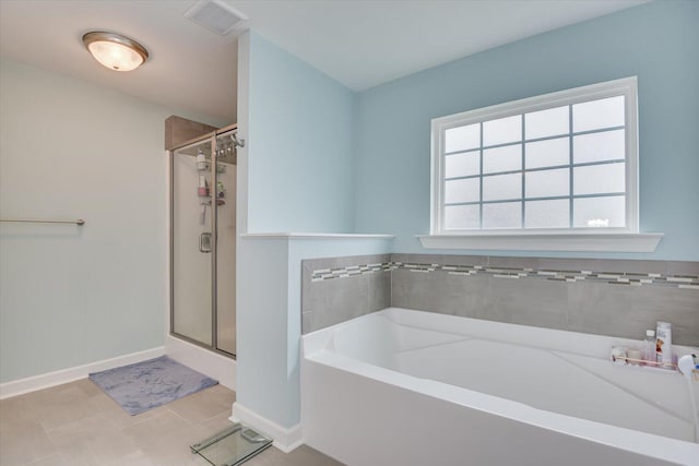 bathroom with tile patterned floors and shower with separate bathtub