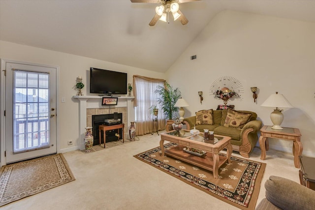 living room with high vaulted ceiling, a tiled fireplace, ceiling fan, carpet, and visible vents