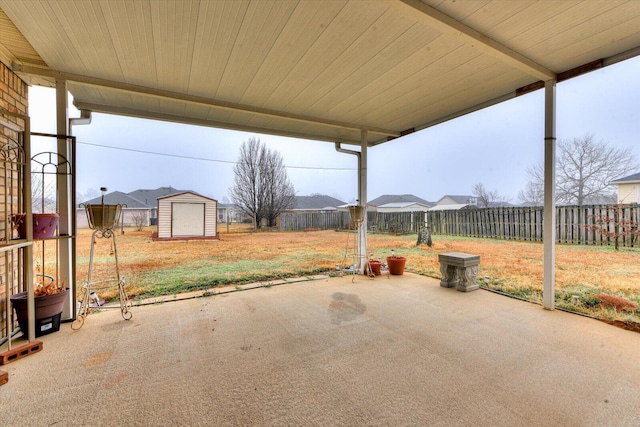 view of patio featuring a fenced backyard, an outdoor structure, and a storage shed