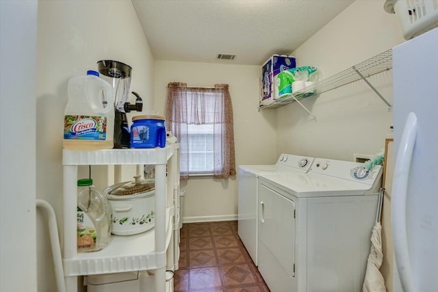 laundry area featuring laundry area, visible vents, baseboards, separate washer and dryer, and a textured ceiling
