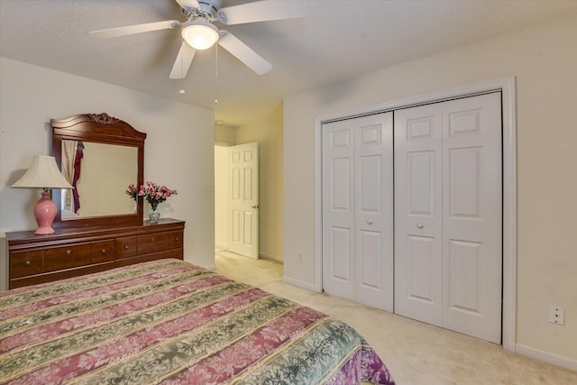 bedroom with a ceiling fan, baseboards, a closet, and carpet