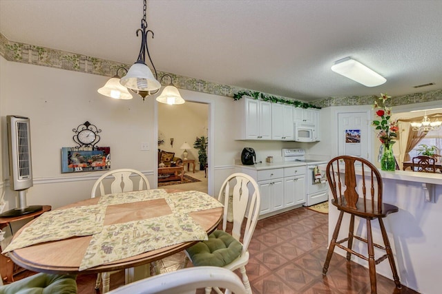 dining area with a textured ceiling and visible vents