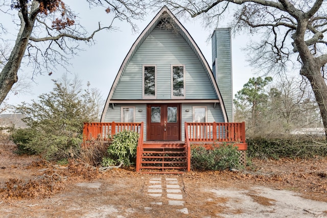 a-frame style home featuring a deck and a chimney