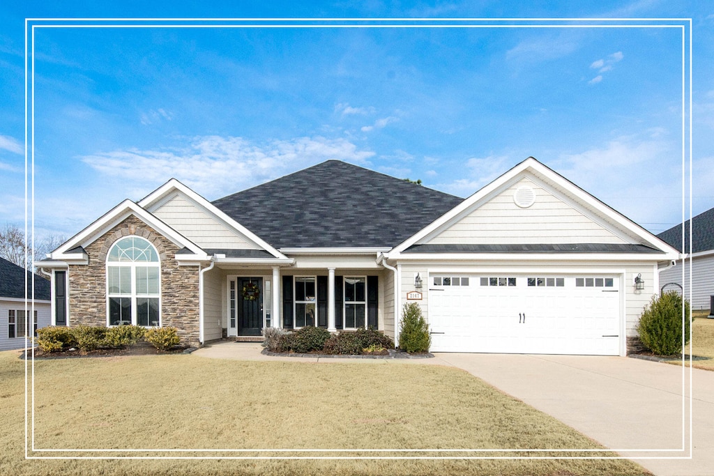 view of front of house with a garage and a front lawn