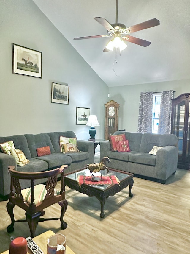 living room featuring ceiling fan, light wood-type flooring, and vaulted ceiling