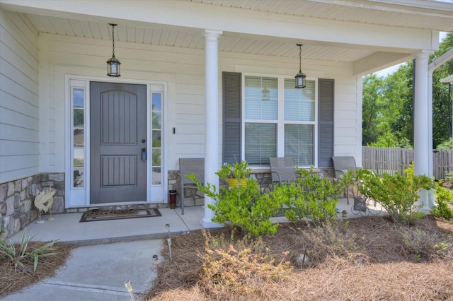 203 Preston Ct, North Augusta, SC 29860 - view of exterior entry with fence, a porch, and stone siding
