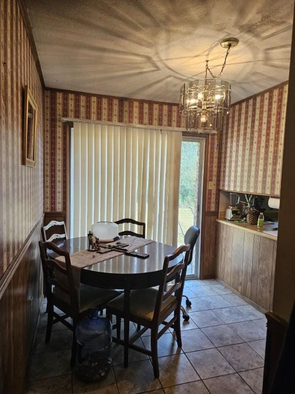 dining space with tile patterned flooring and a notable chandelier