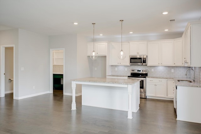 215 Palisades Rdg, Evans, GA 30809 - kitchen featuring a sink, stainless steel appliances, decorative backsplash, light stone counters, and a kitchen island