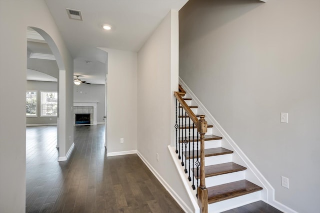215 Palisades Rdg, Evans, GA 30809 - staircase with a ceiling fan, wood finished floors, baseboards, arched walkways, and a tiled fireplace