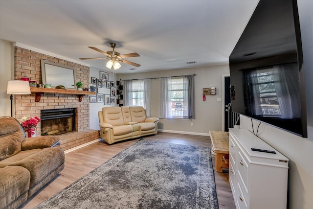 living room with a fireplace, visible vents, and wood finished floors