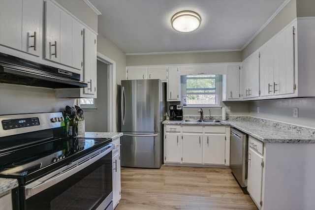 kitchen featuring under cabinet range hood, a sink, appliances with stainless steel finishes, light wood-type flooring, and crown molding