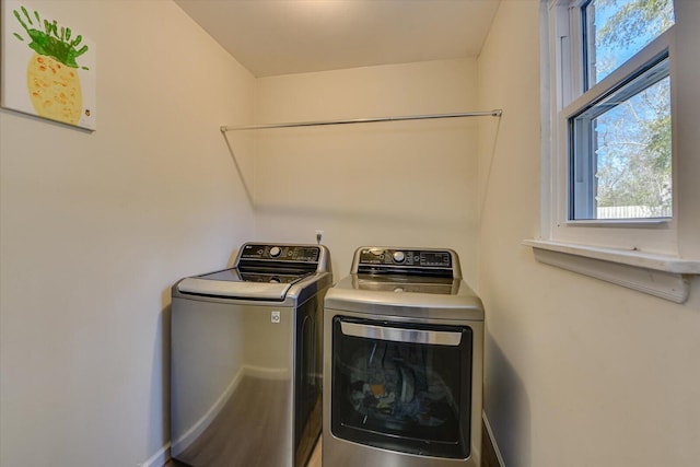 washroom with washer and dryer, laundry area, and baseboards