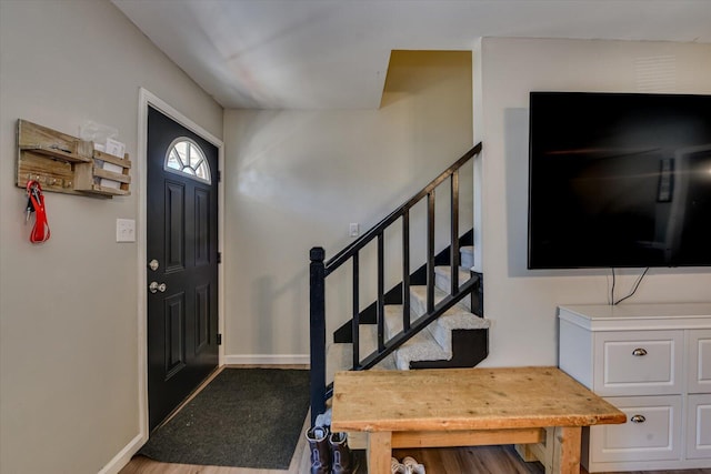 foyer entrance with stairway and baseboards