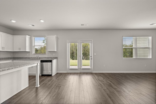 1256 Birch Cir, Grovetown, GA 30813 - kitchen with stainless steel dishwasher, dark wood finished floors, white cabinets, light stone counters, and baseboards