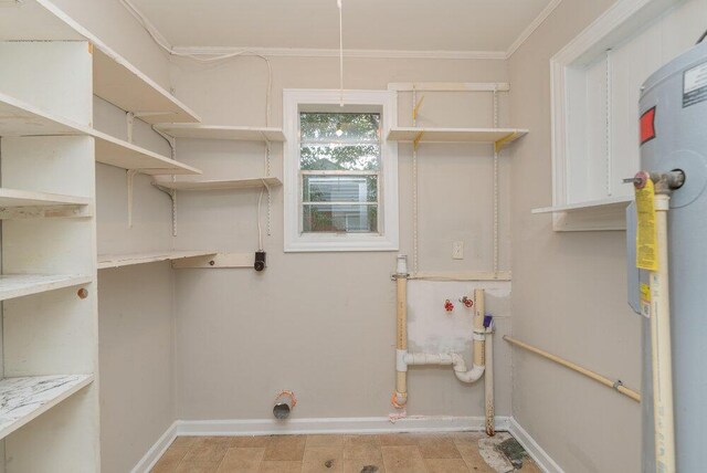 laundry room featuring ornamental molding and water heater