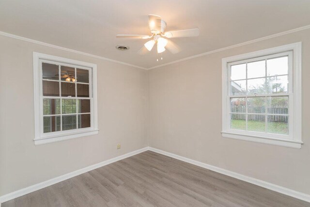 empty room with hardwood / wood-style floors, ceiling fan, and crown molding