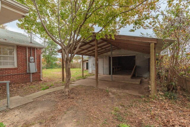 view of yard featuring a carport, a garage, and an outdoor structure