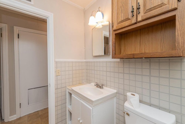 bathroom featuring crown molding, vanity, tile walls, and toilet