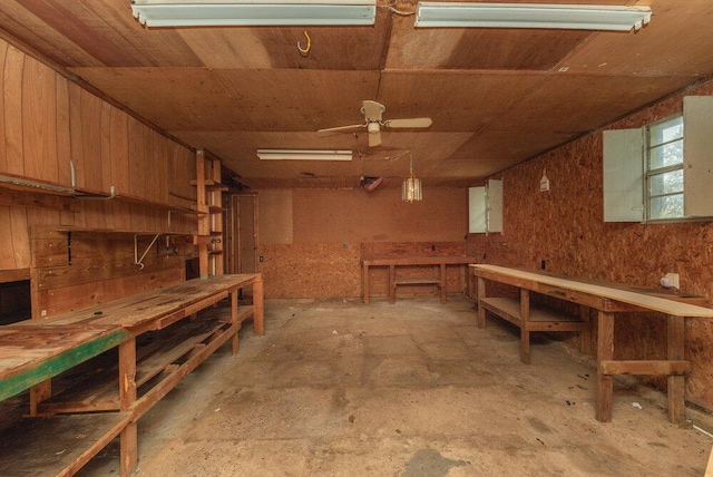 basement with a workshop area, wood walls, ceiling fan, and wood ceiling