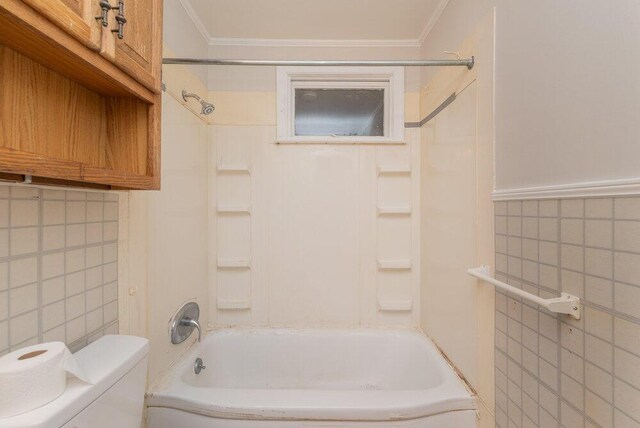 bathroom featuring shower / bathing tub combination, tile walls, and crown molding