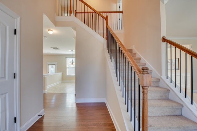 staircase featuring hardwood / wood-style flooring and a towering ceiling