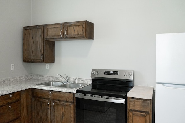 413 2nd St, Augusta, GA 30901 - kitchen featuring electric stove, freestanding refrigerator, a sink, dark brown cabinets, and light countertops