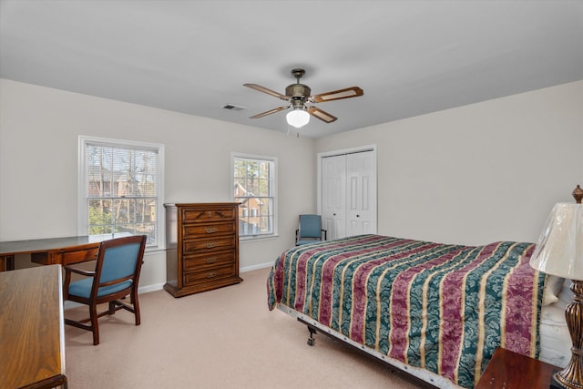 carpeted bedroom featuring ceiling fan and a closet