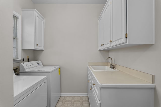 washroom with cabinets, sink, and washing machine and clothes dryer