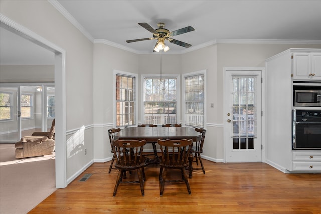 dining space with crown molding, ceiling fan, and light hardwood / wood-style floors