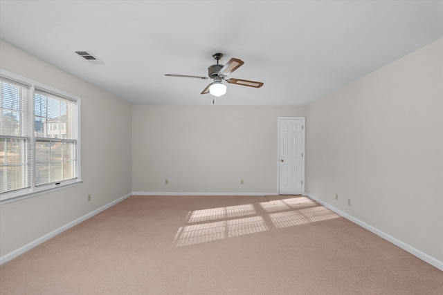 spare room featuring ceiling fan and light colored carpet