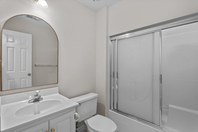 full bathroom featuring vanity, toilet, and combined bath / shower with glass door