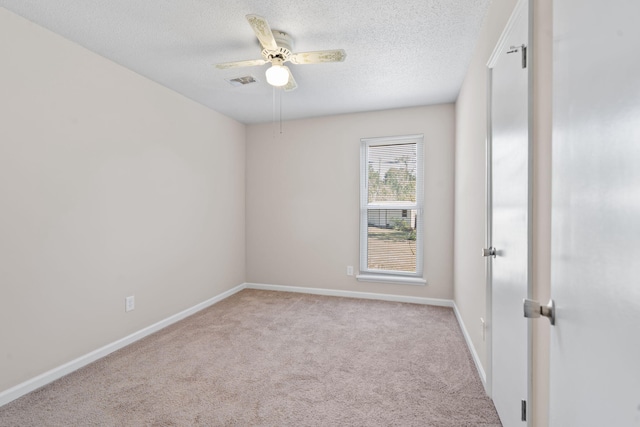 carpeted empty room featuring baseboards, a ceiling fan, visible vents, and a textured ceiling