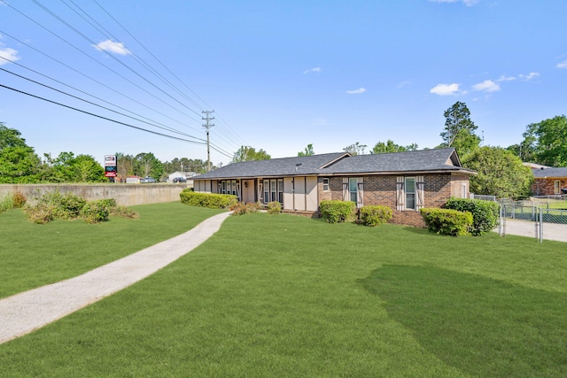 exterior space with a lawn, a gate, fence, and brick siding