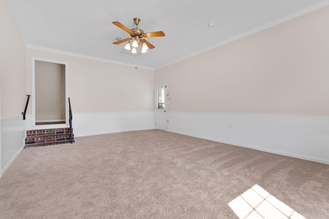 carpeted empty room featuring a ceiling fan and ornamental molding