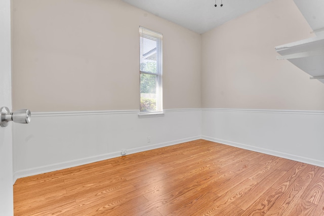 spare room featuring light wood-type flooring and baseboards