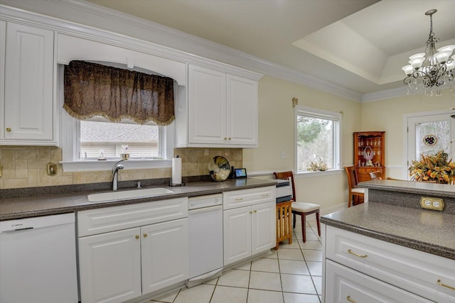 kitchen with decorative backsplash, white cabinets, a tray ceiling, sink, and dishwasher