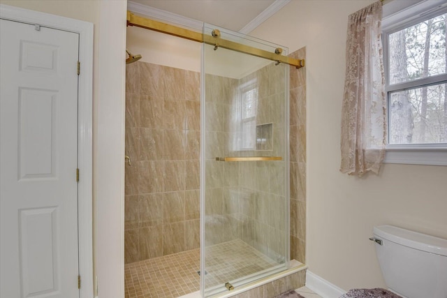 bathroom featuring crown molding, a shower with shower door, and toilet