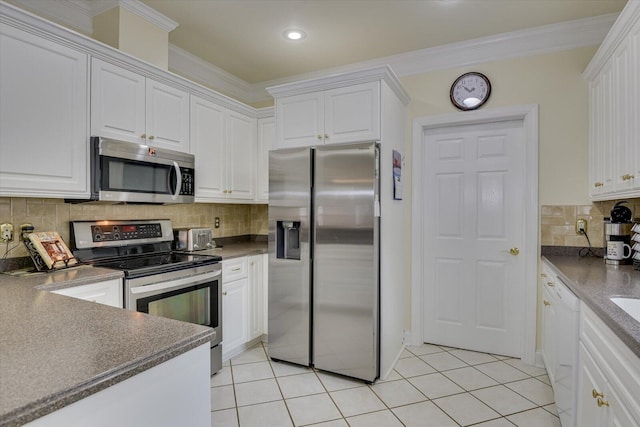 kitchen featuring crown molding, white cabinetry, stainless steel appliances, and tasteful backsplash