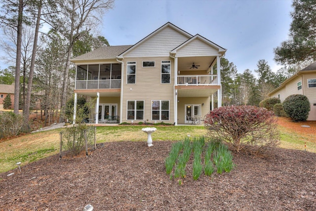 rear view of house with a lawn, a sunroom, ceiling fan, a balcony, and a patio area