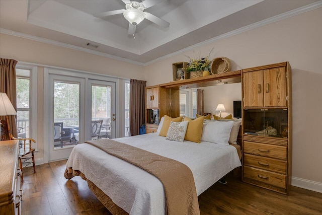 bedroom with access to exterior, ceiling fan, dark hardwood / wood-style flooring, a tray ceiling, and ornamental molding