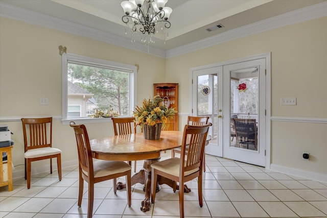 tiled dining room with a chandelier, french doors, crown molding, and a tray ceiling