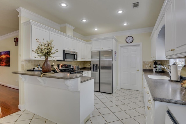 kitchen with kitchen peninsula, white cabinetry, sink, and appliances with stainless steel finishes