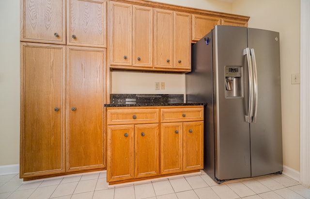3701 Wexford Dr, Martinez, GA 30907 - kitchen featuring stainless steel refrigerator with ice dispenser, brown cabinetry, dark stone countertops, and light tile patterned floors