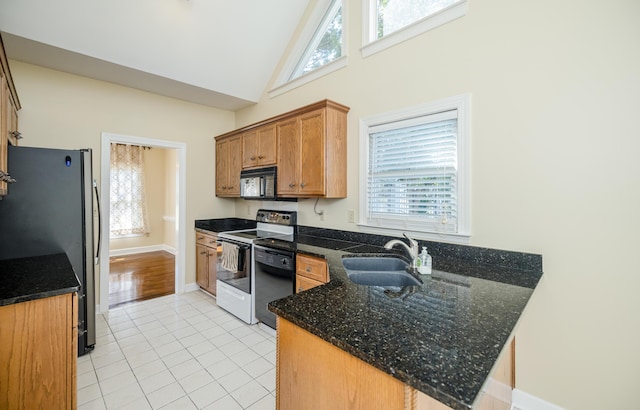 3701 Wexford Dr, Martinez, GA 30907 - kitchen with black appliances, plenty of natural light, high vaulted ceiling, light tile patterned floors, and a peninsula