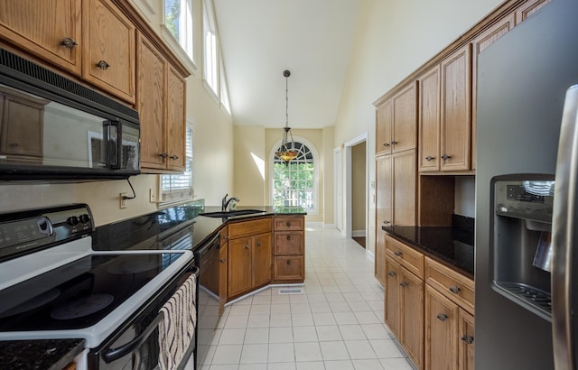 3701 Wexford Dr, Martinez, GA 30907 - kitchen with black appliances, high vaulted ceiling, light tile patterned flooring, brown cabinets, and hanging light fixtures