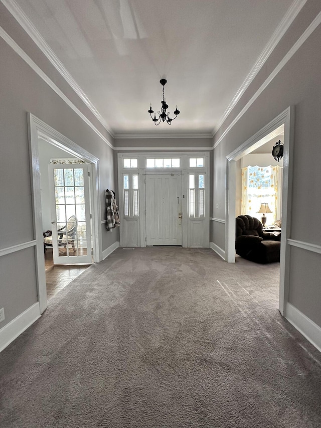 carpeted foyer with a chandelier and ornamental molding