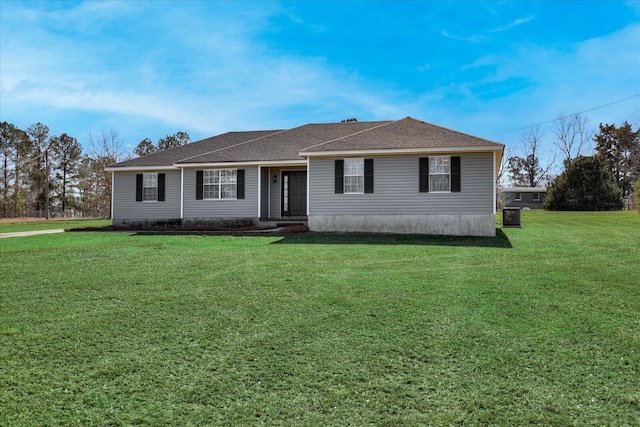 view of front of property with roof with shingles and a front lawn