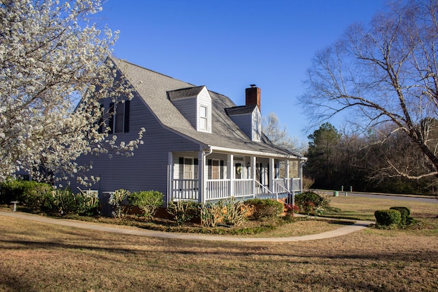 view of home's exterior with a porch, a lawn, a chimney, and a shingled roof