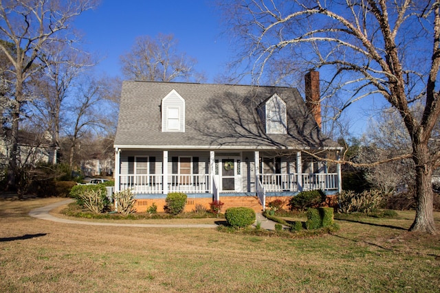 cape cod house with covered porch, a chimney, a front lawn, and roof with shingles