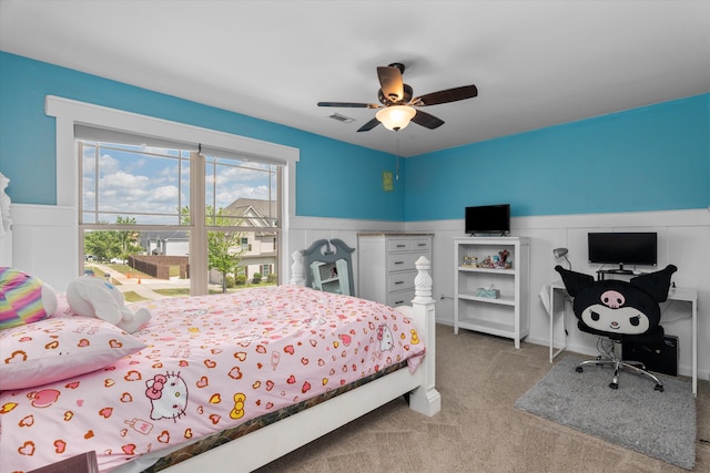 bedroom featuring visible vents, ceiling fan, a wainscoted wall, and carpet floors